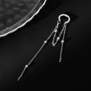 Detail of silver long tassel ear clip with C-shaped cuff and metal bead chains