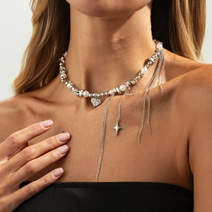 Detail of necklace with white pearls, silver beads, heart zircon, and star fringe