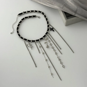 Detail of silver tassel necklace with angel heart charms and black woven chain design