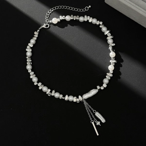 Detailed view of pearl necklace with star accents and cascading metal fringe tassels