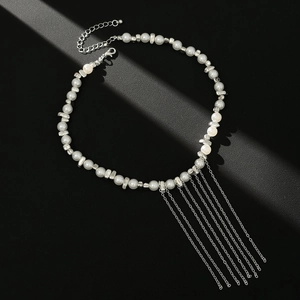 Detail of pearl necklace with cascading silver tassels and lobster clasp on black surface