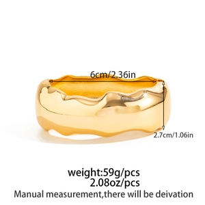 Detail view of wavy gold metal cuff bangle with 6cm inner diameter and 2.7cm width