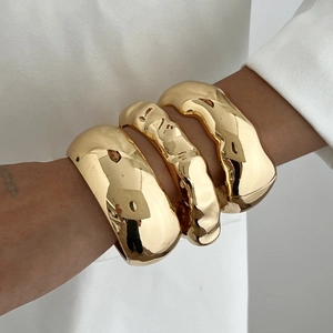 Three-piece set of chunky irregular gold bracelets with a high-polished mirror finish