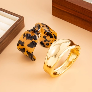 Détails d'un bracelet nœud léopard écaille et d'un bracelet épais doré poli
