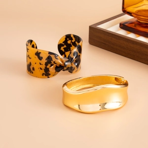 Détail d'un bracelet nœud en résine écaille de tortue et d'un jonc doré irrégulier