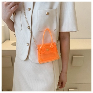 Détail du mini sac bandoulière transparent orange fluo avec chaîne dorée et rabat