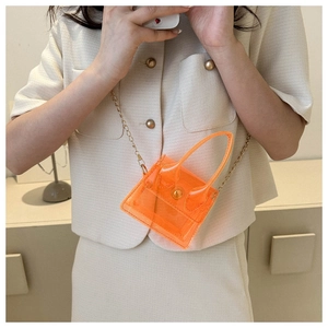 Vue détaillée du mini sac bandoulière en PVC orange transparent avec chaîne dorée