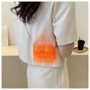 Détail du mini sac bandoulière orange en PVC transparent avec une chaîne dorée