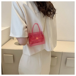 Mini sac à main rose en PVC transparent avec chaîne dorée porté par un mannequin