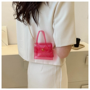Détail d'un mini sac bandoulière transparent rose avec chaîne dorée sur mannequin