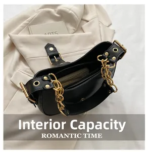 Detail view of black leather underarm bag showing organized internal compartments and gold zipper