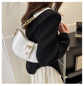 Detail of white leather half-moon shoulder bag with gold chain strap and metal buckle