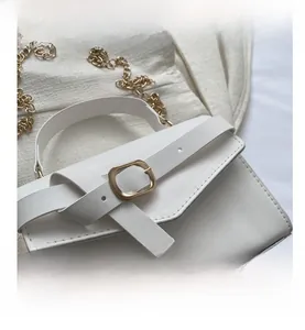 Detail of white leather shoulder bag featuring gold square buckle and metal chain strap