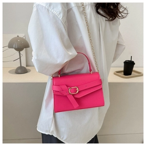Detail of a bright pink PU leather square handbag with golden chain and oval buckle accent