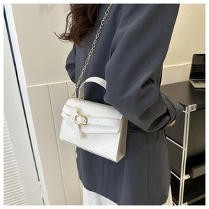 Photo de style d'une femme portant un mini sac blanc en bandoulière avec chaîne dorée