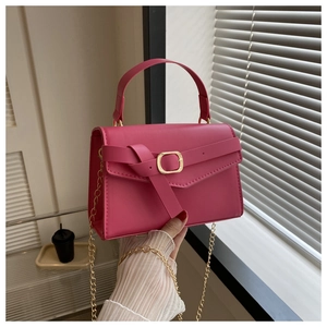Détail du petit sac bandoulière rose fuchsia avec chaîne dorée et boucle métal