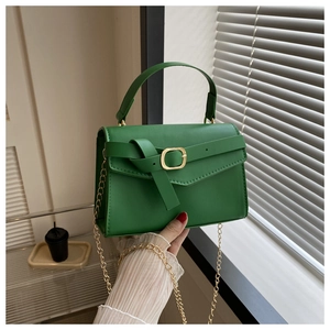Détail du sac bandoulière vert citron avec chaîne dorée et boucle décorative