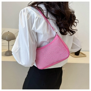 Dettaglio borsa hobo rosa con strass argentati indossata da modella in camicia bianca