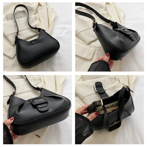 Detail view of black crescent underarm bag showing interior zipper and belt buckle decor