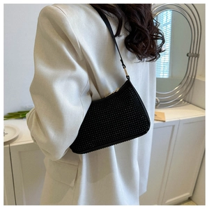 Dettaglio della borsa a spalla in strass neri su blazer bianco dal lussuoso splendore