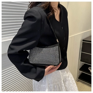 Dettaglio di una borsa hobo scintillante con strass, finitura argento e base nera