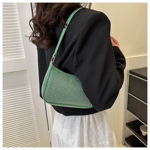 Dettaglio della borsa a tracolla verde con strass scintillanti e finitura di lusso
