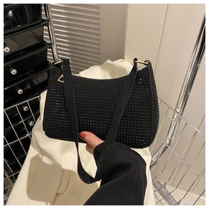 Dettaglio borsa baguette nera con strass, hardware dorato e tracolla larga