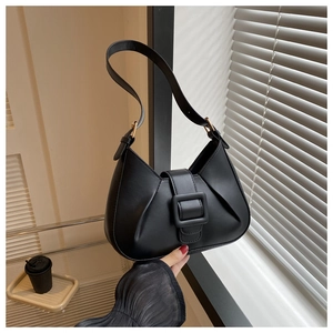 Detailed view of black crescent hobo bag with large buckle and elegant pleated side textures