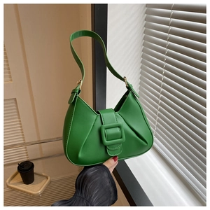 Detailed view of a green faux leather crescent bag with decorative buckle and wide strap