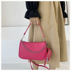 Détail du sac baguette rose rouge avec chaîne argentée et mini porte-monnaie rond