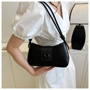 Détail du sac sous le bras en cuir noir avec boucle circulaire et bandoulière à nœud raffiné