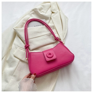 Détail du sac à bandoulière en cuir magenta avec bandoulière nouée et détails dorés