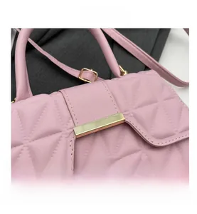 Detalle de bolso acolchado rosa con costuras finas y piezas metálicas en color oro