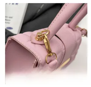 Detalle del bolso de cuero acolchado rosa con el gancho dorado y el asa redonda