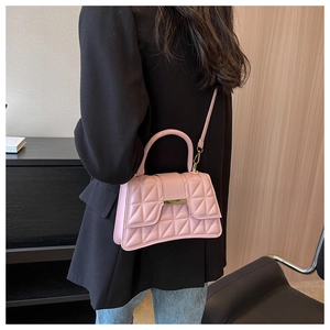 Modelo con bolso rosa acolchado y cierre dorado combinado con blazer negro y jeans