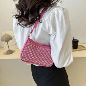 Borsa a spalla rosa fucsia con strass brillanti abbinata a una camicia bianca