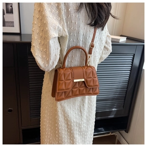 Bolso bandolera acolchado caramelo llevado por modelo en un entorno elegante