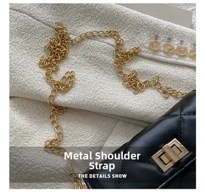 Macro detail of black quilted leather texture and gold hardware chain on small bag