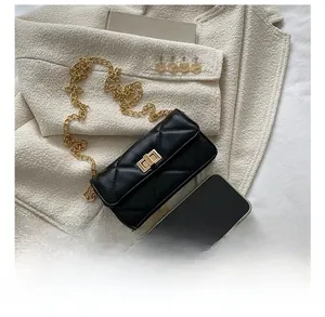 Quilted black leather crossbody bag with gold chain shown next to a smartphone for size comparison