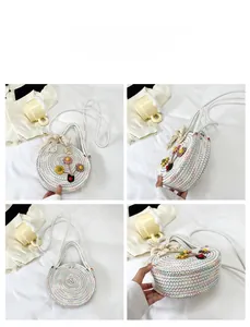 Détails d'un sac rond tressé avec coutures colorées et fleurs artisanales décoratives