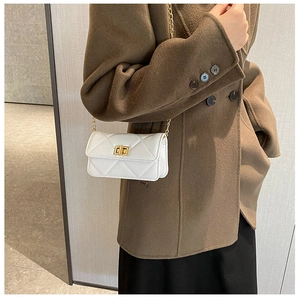 Detailed view of white quilted PU leather crossbody bag with gold chain and metal lock