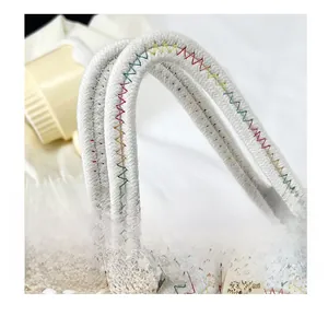 Détail du sac en paille avec poignée en coton, nœud en dentelle et bouton en bois