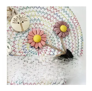 Détail du sac en paille tissé à la main avec fleurs colorées et bouton en bois