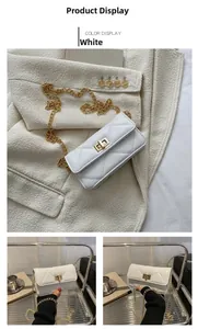 Detail of white quilted crossbody bag featuring a gold twist lock and elegant chain strap