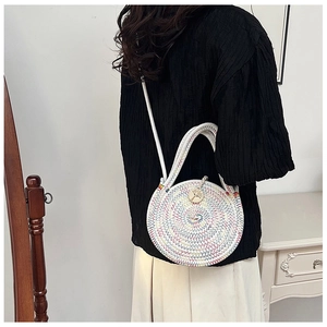 Détail d'un sac rond tissé arc-en-ciel avec bouton en bois et poignée tressée