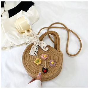Dettaglio della borsa rotonda intrecciata con fiori decorativi e fiocco in pizzo
