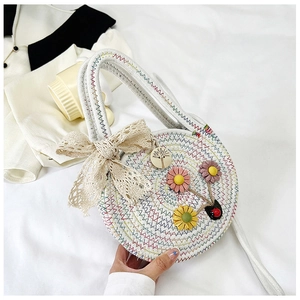 Dettaglio della borsa rotonda tessuta bianca con cuciture colorate, fiocco e fiori