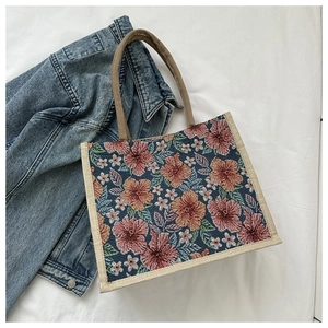 Detail view of jacquard floral tote bag made from textured canvas on a denim backdrop