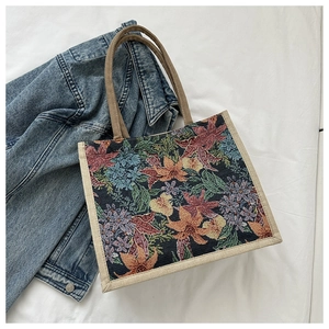 Close-up of vintage floral tapestry tote bag with woven handles and jacquard texture
