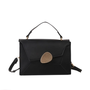 Sac bandoulière trapèze noir chic avec boucle métallique dorée en forme de galet sur fond blanc
